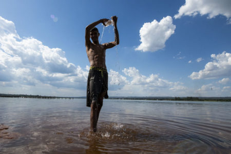 Foto colorida de menina tomando banho no lago Paranoá durante período de altas temperaturas no Brasil - Metrópoles