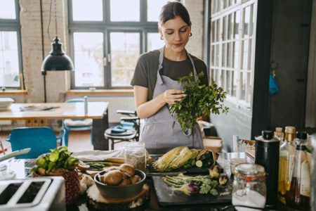 Foto colorida de uma mulher na cozinha - Metrópoles