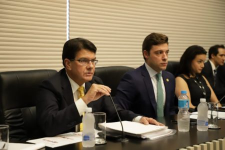 Fotografia colorida mostra Max Xavier Lins, presidente da Enel, um homem branco de cabelos pretos e óculos de aros quadrados e pretos, gravada amarela, camisa branca e terno preto, falando ao microfone em uma bancada na Alesp - Metrópoles