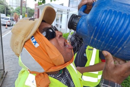 Imagem mostra trabalhador bebendo água em meio ao calor - Metrópoles