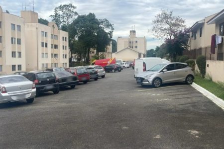 imagem colorida mostra estacionamento com carros e predio em curitiba - Metrópoles