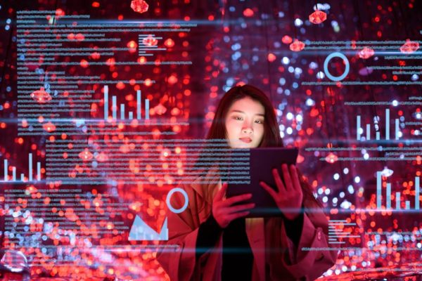 Imagem de jovem de origem asiática mexendo em um dispositivo móvel, cercada por um efeito de imagens que remetem à tecnologia e à velocidade da internet - Metrópoles