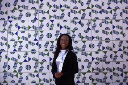 Imaegem colorida de mulher com roupa preta na frente de mural de azulejos. Doutora UnB cotada ao STF