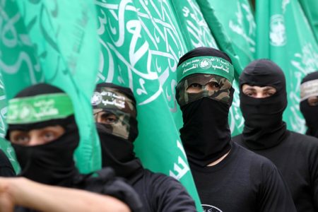 Imagem colorida mostra membros do Hamas usando balaclavas e segurando bandeiras do grupo - Metrópoles