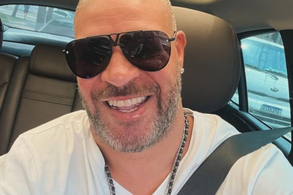 Adriano Imperador posa de óculos escuros e sorridente dentro do carro - Metrópoles