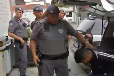 Imagem colorida mostra policial militar (PM) tirando um homem de dentro de uma viatura. Ele foi um dos ladrões presos dentro de um shopping na zona leste de São Paulo após entrar no local para fugir dos policiais, que o perseguiam por ele integrar uma quadrilha que fazia arrastões na região - Metrópoles