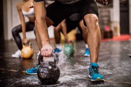 Foto de homem fazendo exercício físico com kettlebell - Metrópoles