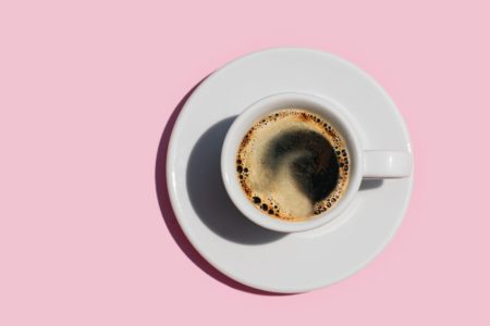 xícara de café em fundo rosa