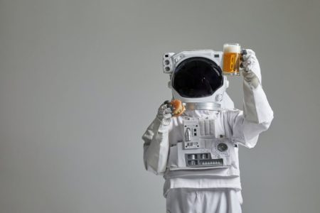 astronauta segurando um hambúrguer e um copo de cerveja