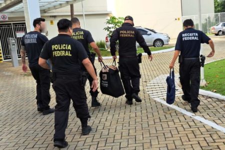 Imagem de agentes da Polícia Federal e Receita Federal caminhando com bolsas - Metrópoles