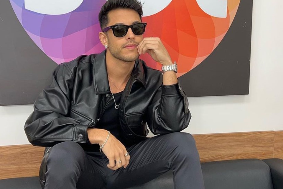 Kevi Jonny posa perto da logo do SBT usando look preto - Metrópoles