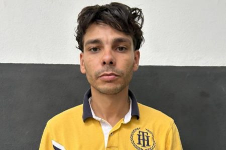 Imagem colorida mostra Caio Augusto Santos Farias, um homem branco, de cabelos castanho-escuros, sem barba, vestido com uma camiseta polo amarela com a gola preta - Metrópoles