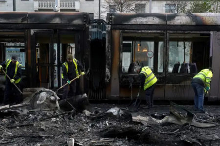 Funcionários limpam infraestrutura de transporte que foi incendiada no centro de Dublin