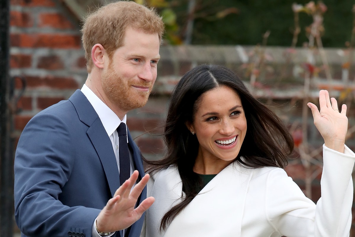 Harry e Meghan aparecem sorridentes e acenando para os fotógrafos durante anúncio de noivado em 2017 - Metrópoles