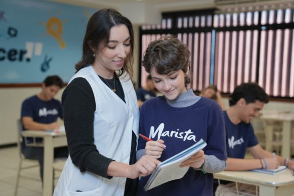 Fotografia colorida mostrando professora e aluna-Metrópoles