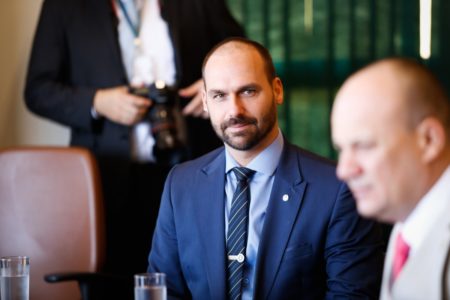 Tarcísio Imagem colorida mostra Eduardo Bolsonaro, homem branco, calvo, de terno azul, sentado em uma mesa, olhando para frente - Metrópoles