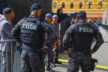 Imagem colorida mostra PMs da Rota, uniformizados, conversando em um círculo, dentro do batalhão da Rota em SP - Metrópoles