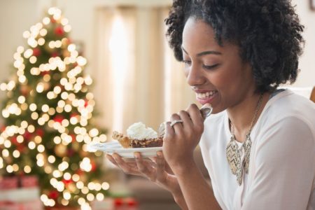 Foto colorida de uma mulher comendo doce - Metrópoles