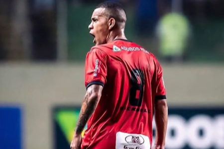 Imagem colorida de jogador de futebol com uniforme vermelho, de costas - Metrópoles