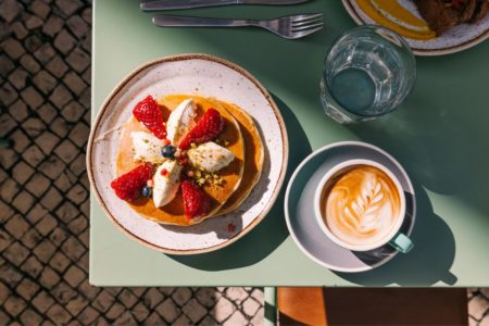 prato de panqueca doce ao lado de uma xícara de café