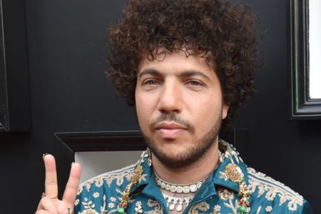 Foto de um homem branco, com cabelo castanho cacheado e cheio, barba preta, usando blusa azul florida - Metrópoles