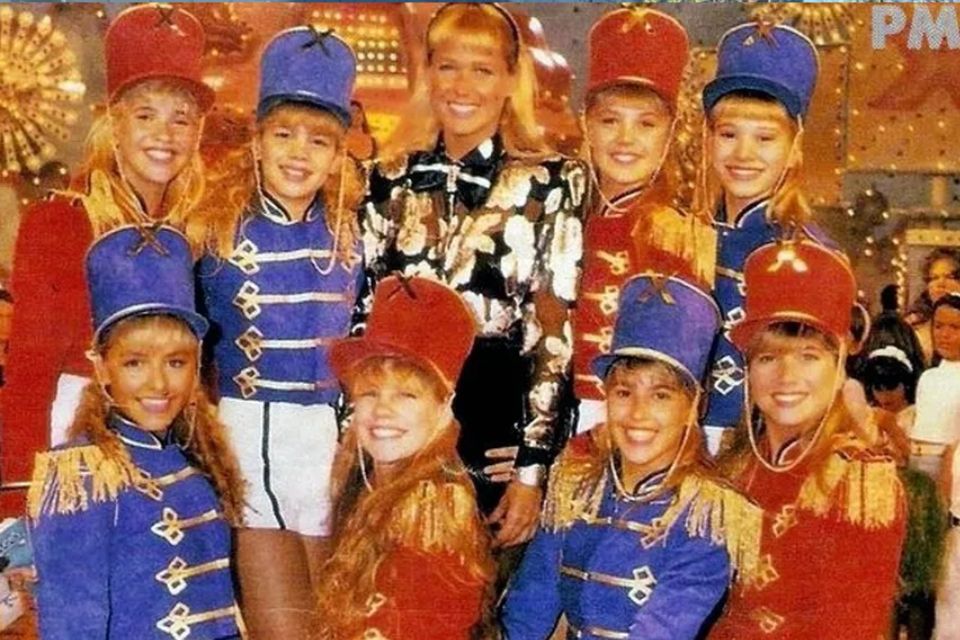 Foto colorida de Xuxa e suas Paquitas - Metrópoles