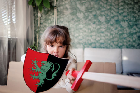 Foto mostra menina com espada e escudo de brinquedo, perigosos para os olhos