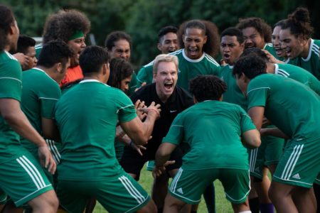 foto colorida de varios homens de uniforme de futebol verde em circulo com homem de preto no meio gritando - metrópoles