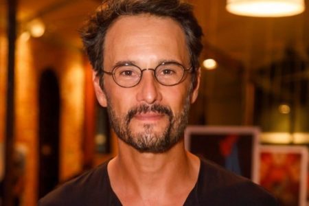 Rodrigo Santoro posa de óculos e blusa preta - Metrópoles
