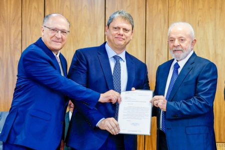 Imagem colorida mostra Alckmin, Tarcísio e Lula, segurando um papel para mostrar aos fotógrafos, no Planalto. Os 3 estão de terno azul - Metrópoles