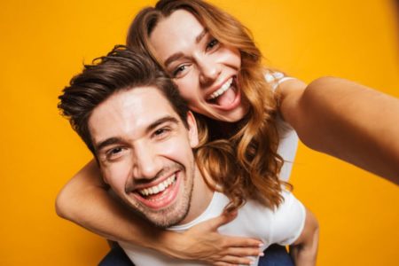 Casal se abraçando e tirando uma self