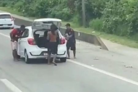 foto colorida de assaltantes atacando carros parados em congestionamento na rodovia Cônego Domênico Rangoni, no Guarujá - Metrópoles