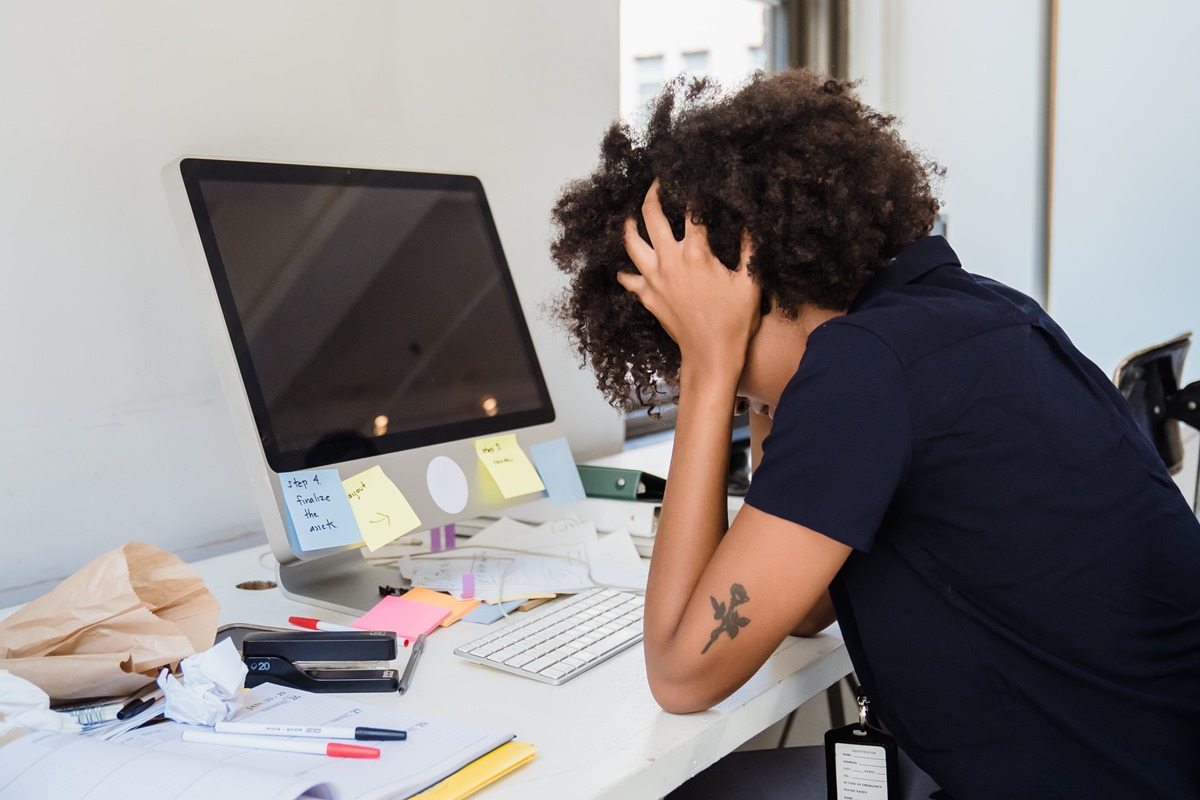 Mulher com as mãos na cabeça de frente para o computador - Metrópoles