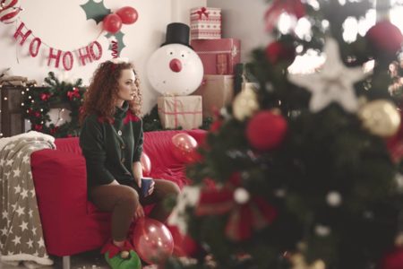 Imagem colorida de pessoa sentada sozinha e triste no Natal - Metrópoles