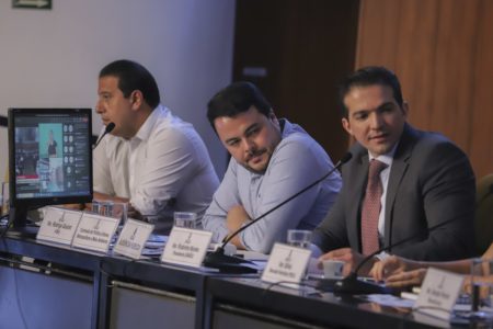 Imagem colorida mostra vereadores sentados em uma mesa no palco do auditório da Câmara Municipal de SP - Metrópoles