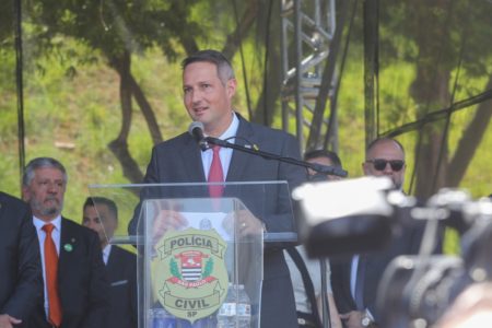 Imagem colorida mostra Guilherme Derrite falando ao microfone - Metrópoles