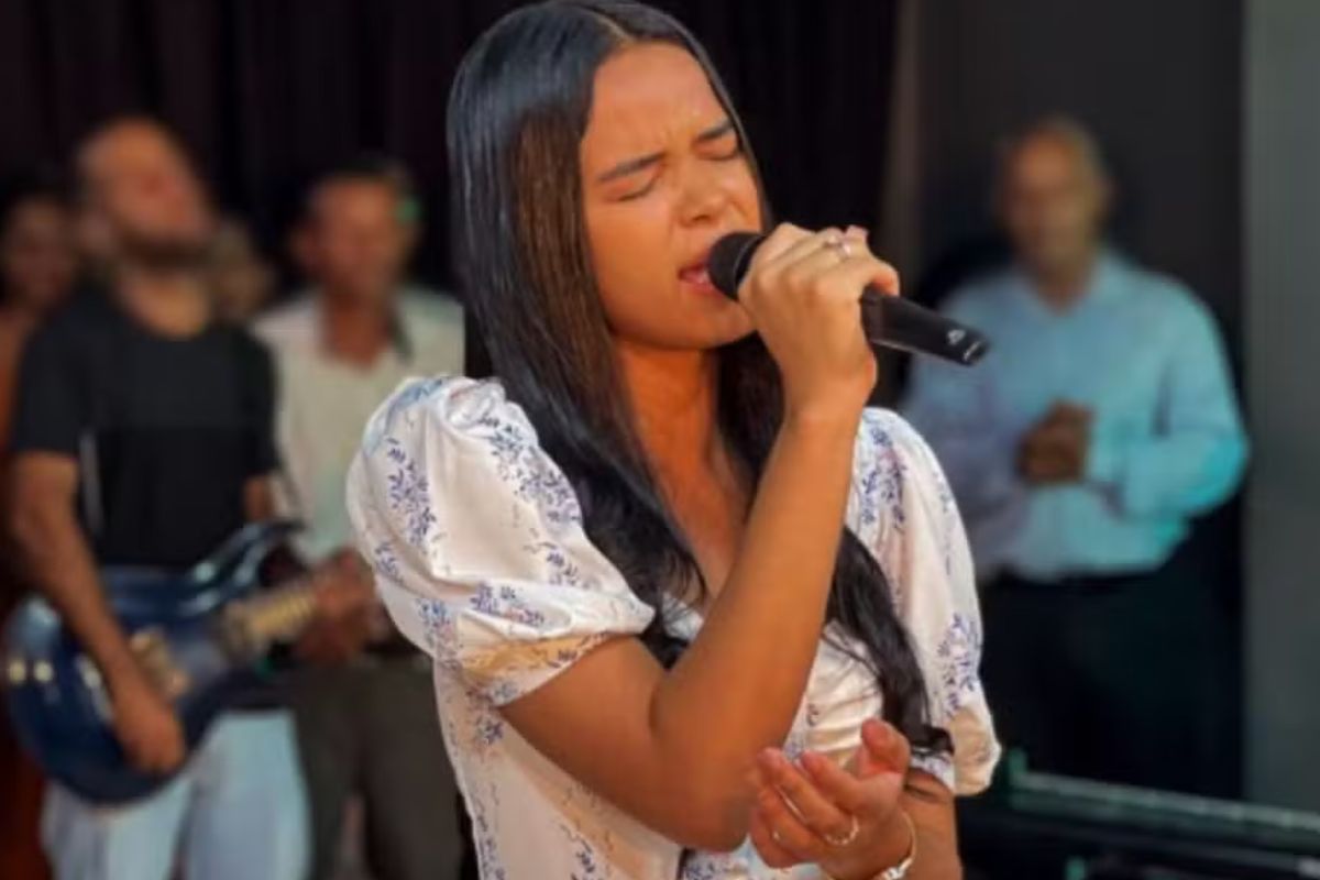 Foto colorida da cantora gospel Aclécia Silva cantando - Metrópoles