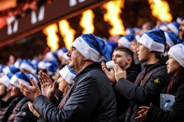 Imagem colorida de torcedores do Chelsea, na Inglaterra, usando gorros de papai noel na rodada do natal da Premier League- Metrópoles