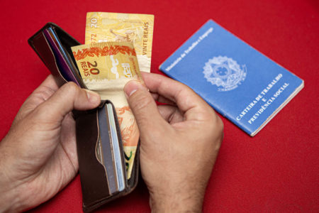 Carteira de trabalho e dinheiro de salário mínimo -- Metrópoles