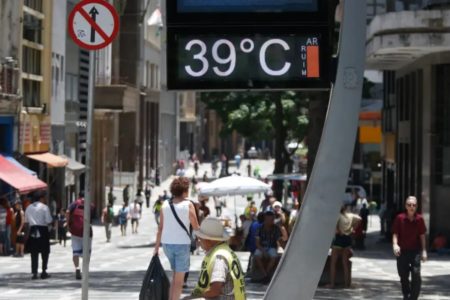 foto colorida de paulistanos caminhando sob o sol no centro de SP, com termômetro marcadno 39 graus - Metrópoles