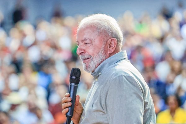 Imagem colorida do presidente Lula sorrindo com um microfone e plateia desfocada ao fundo, em evento em Teresina, no Piauí - Metrópoles