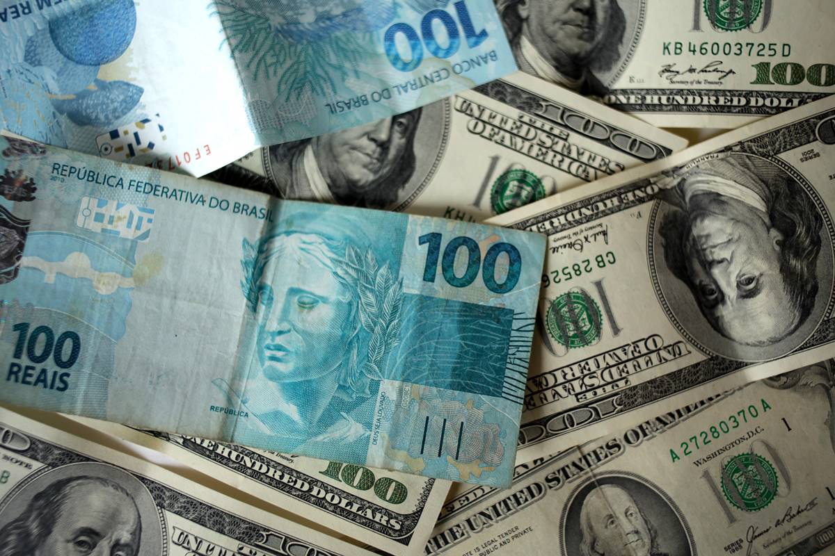 Imagem de várias cédulas de dólar e real - Metrópoles