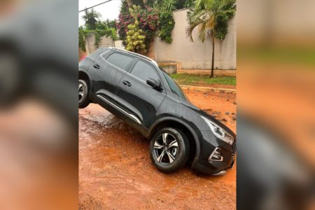 Imagem colorida de carro preso em buraco - Metrópoles