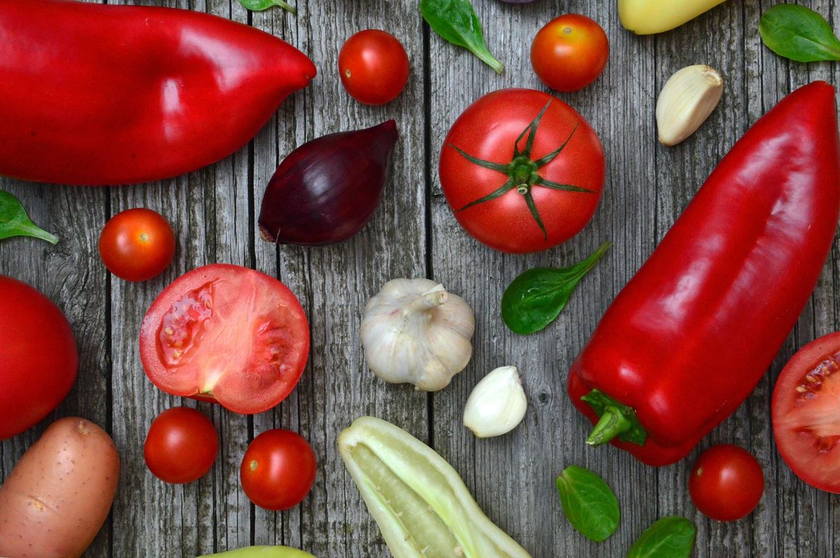 Diferentes vegetais, como pimentão, tomate, alho e cebola em uma mesa - Metrópoles