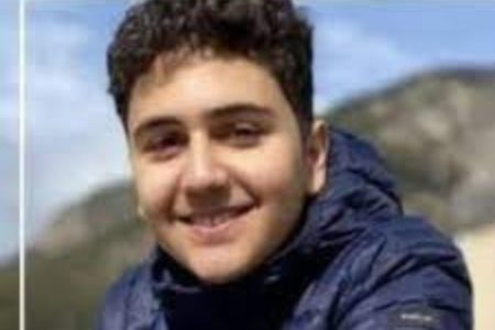 Imagem de adolescente Arthur Sampaio Flores, de 14 anos. Ele está de casaco e sorri para a câmera - Metrópoles