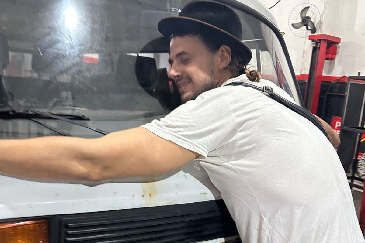 Foto colorida de Daniel Erthal abraçando a kombi - Metrópoles