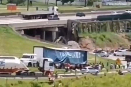 Imagem colorida mostra caminhão sendo saqueado por pessoas após sofrer acidente perto da rodovia Dutra, no interior de São Paulo