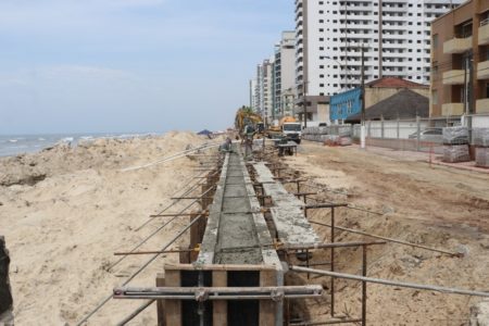Imagem mostra muro de contenção em praia - Metrópoles