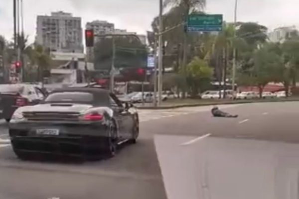 Imagem colorida de homem armado e Porsche preto em rua do Rio de Janeiro - Metrópoles