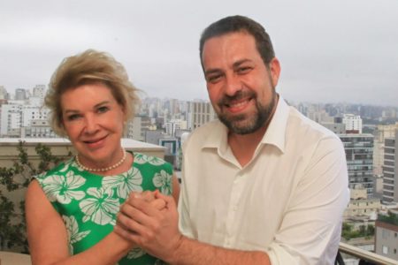 Imagem colorida mostra Marta Suplicy, mulher branca, loira, de olhos azuis, de braços dados com Guilherme Boulos, homem branco, de cabelo, barba e olhos castanhos - Metrópoles